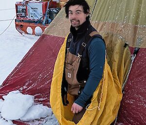 Expeditioner coming out of a tent in the snow