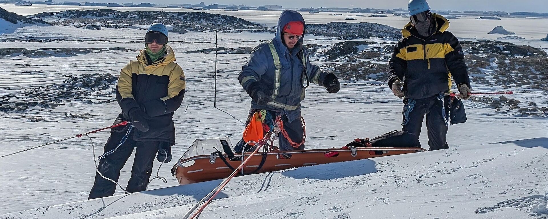 Expeditioners undertaking training with a stretcher on the ice