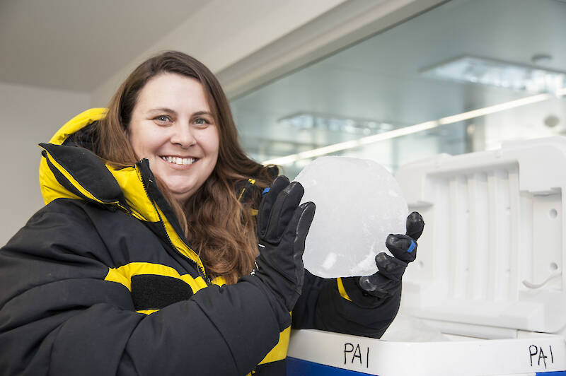 A woman holding a circular piece of ice.