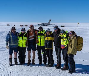 A group of expeditioners arm in arm on the ice