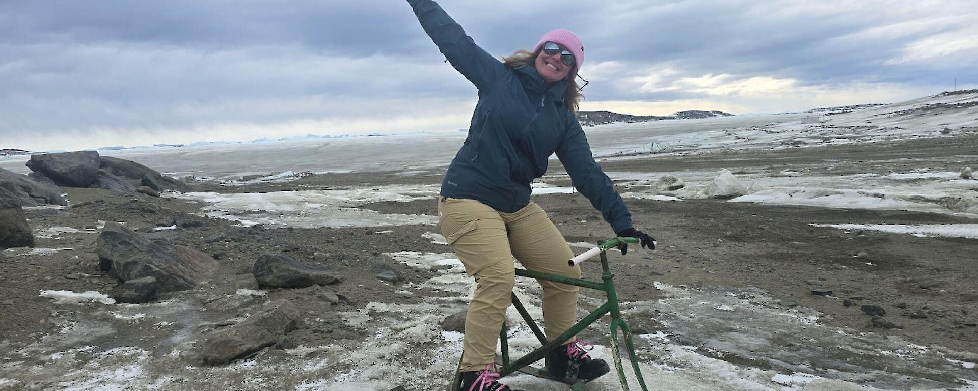 A woman celebrates on a 'ski bike' which is like a tricycle but with small skis in place of wheels