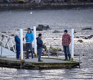 Image of 4 people standing on wharf.