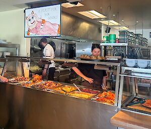A buffet selection in a bain marie with a sign above featuring Miss Piggy an the phrase 'A Feast for Your Senses'