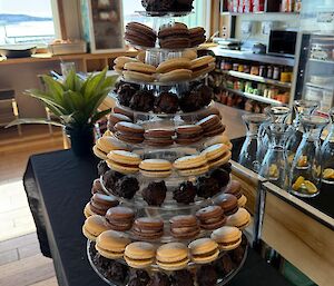A multi-tiered display stand covered with chocolate and salted caramel macarons and chocolate truffles