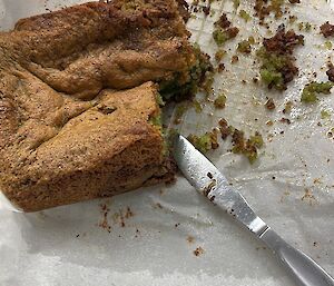 A cake on a tray being cut with a knife