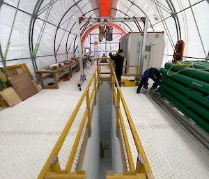 Yellow guard rails around a deep cut in the ice.