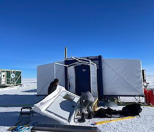 A door being put on a hut standing on the snow