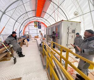 People working on equipment in a white tent