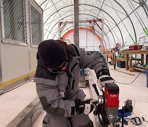 A person using equipment to secure the concrete frame