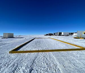 A large wooden frame on a white snowy flat