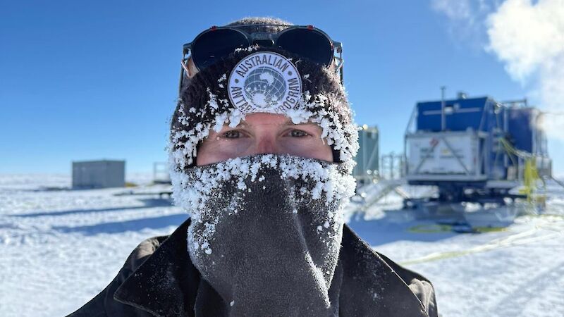 A man with snow all over his beanie and buff