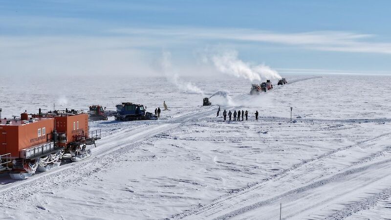 Tractors and people meeting at a cross road on the ice.
