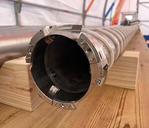 The end of a long steel, cylinder with sharp cutting edges.