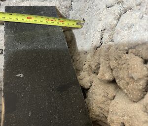 A tape measure against the wall of the rendered incinerator