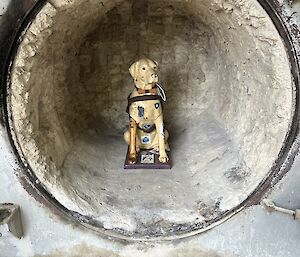 A plastic Guide Dogs Australia dog sitting inside the partially rendered incinerator.