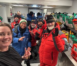A female doctor showing a team from the French/Italian traverse around a medical facility inside a shipping container.