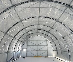 The inside of a cylinder-shaped structure revealing a steel frame covered in an insulating tarpaulin.