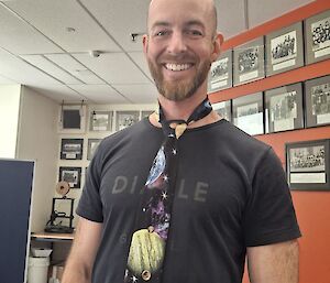 Josh standing in the foreground, proudly wearing his space tie, the lower lounge area in the background.