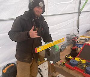 A man standing beside a levelling ruler on a bench.