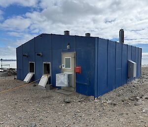 A blue building, with ventilation windows open