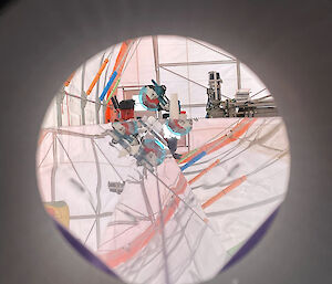 View through a circular hole of a reflective metal surface.