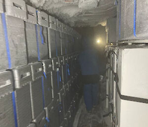 Boxes line two walls on each side of a tunnel built under ice.