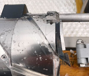Side view of the end of an ice core drilling barrel showing a bent piece of metal