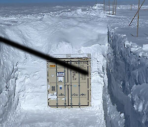 A shipping container in a deep trench in the ice, ready to receive ice core boxes for cold storage.