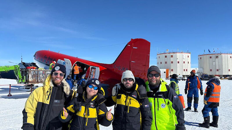 Four people standing in front of a red and white Basler aircraft at Concordia station in Antarctica.