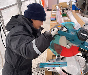 A woman using a circular saw to cut an ice core.