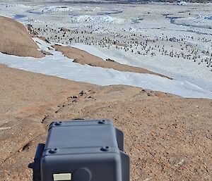 A black camera is pointing out towards an icy landscape