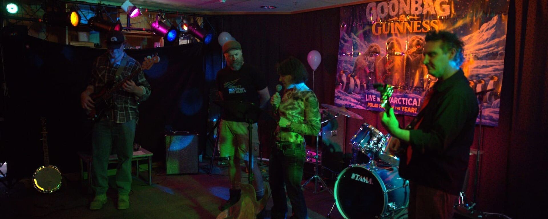 A dimly lit room with musicians playing guitars and drums