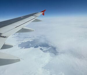 View of ice from an aircraft window, with the aircraft wing visible