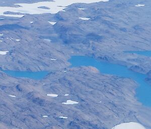 Aerial view of rocky, snow covered hills.