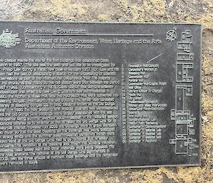 A plaque mounted to a rock includes a history and a map of the early layout of Davis Station