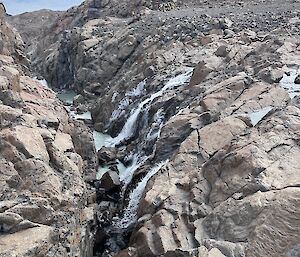 Water flows off rocks into a creek