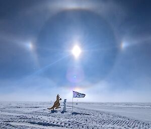 A kangaroo cutout and an Australian flag stand under the sun