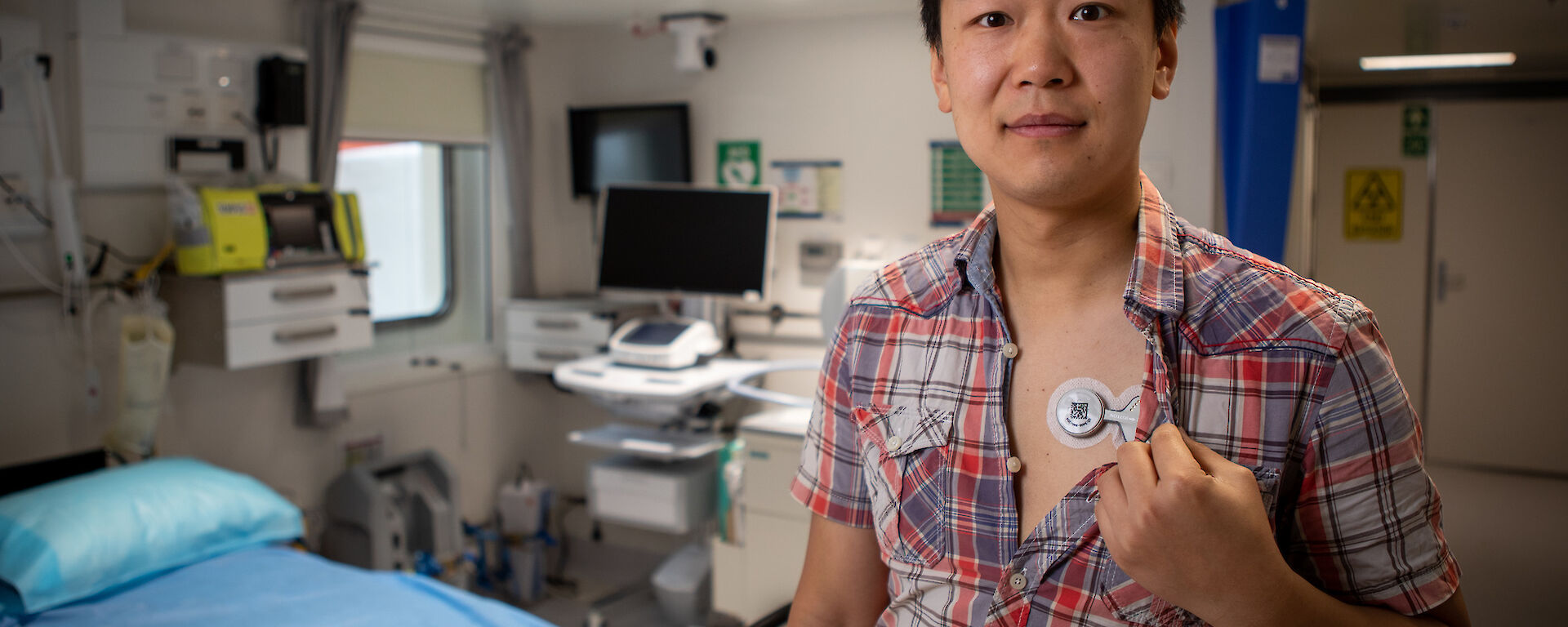 A doctor has a small medical instrument attached to his chest.