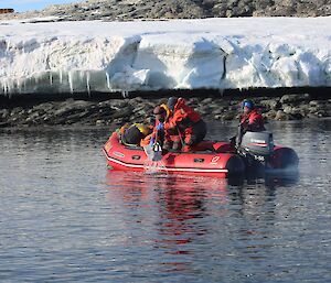 Three people are pictured in the red IRB in the foreground, two people taking samples and one driver at the tiller. The Wilkes shoreline in the background